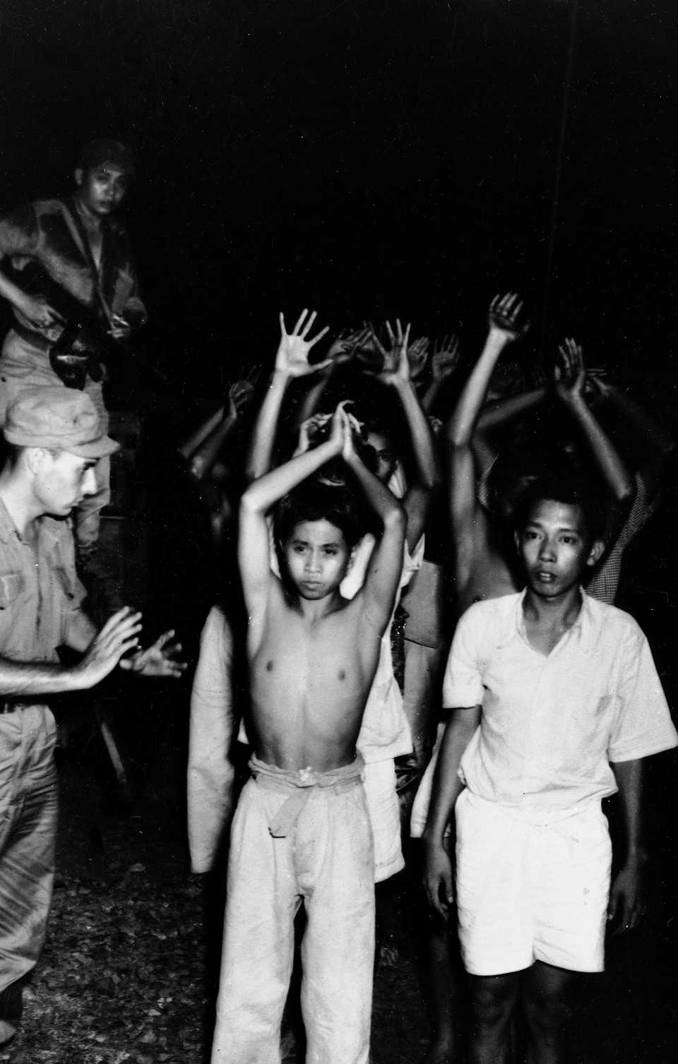 Young Indonesians were ordered to keep their hands up when Dutch soldiers rounded up Republicans in Batavia, July 30, 1947, just before the outbreak of hostilities in Java.