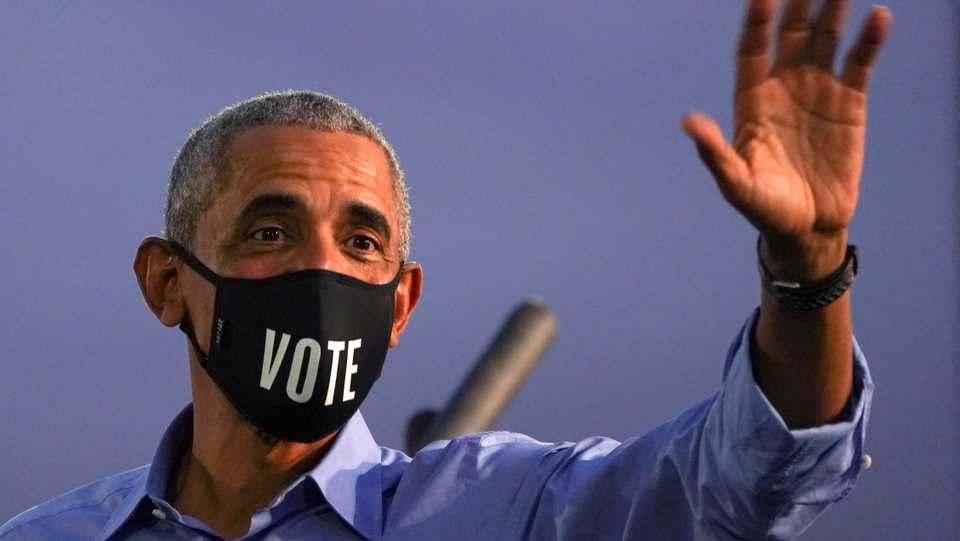 Former US President Barack Obama waves while wearing a 