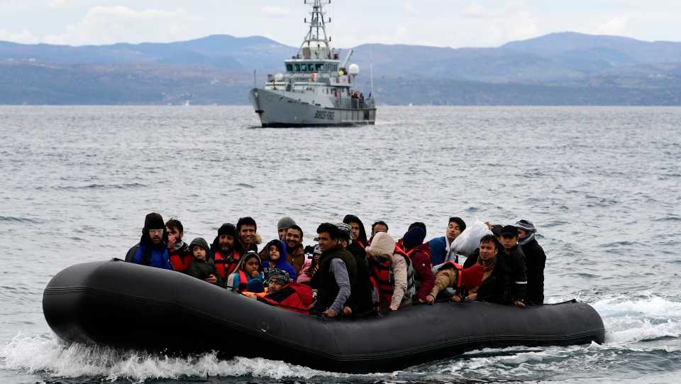 Migrants arrive in a dinghy accompanied by a Frontex vessel at the village of Skala Sikaminias, on the Greek island of Lesvos, after crossing the Aegean Sea from Turkey, on February 28, 2020.