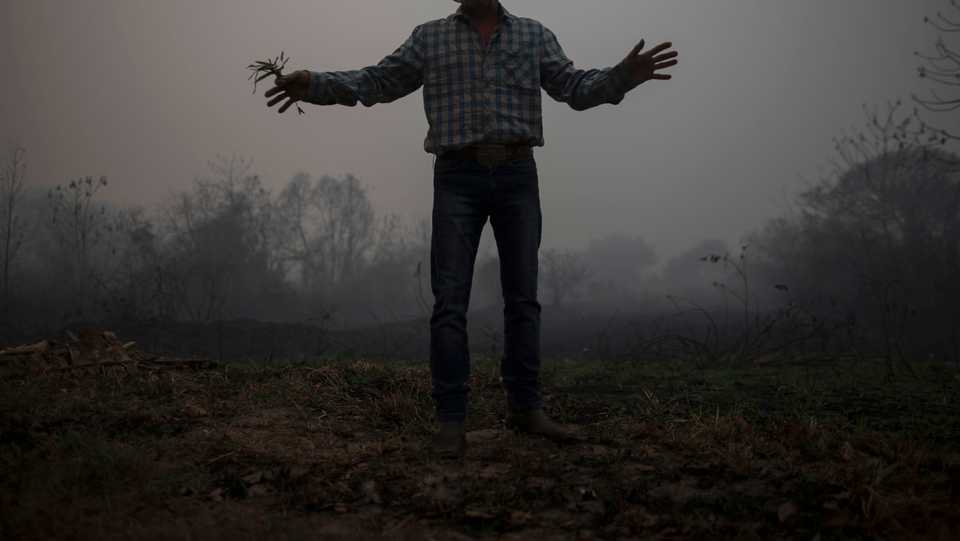 In this file picture taken on September 13, 2020 a man gestures in a burnt area of the Pantanal, near the Transpantaneira park road which crosses the world's largest tropical wetland, in Mato Grosso State, Brazil.