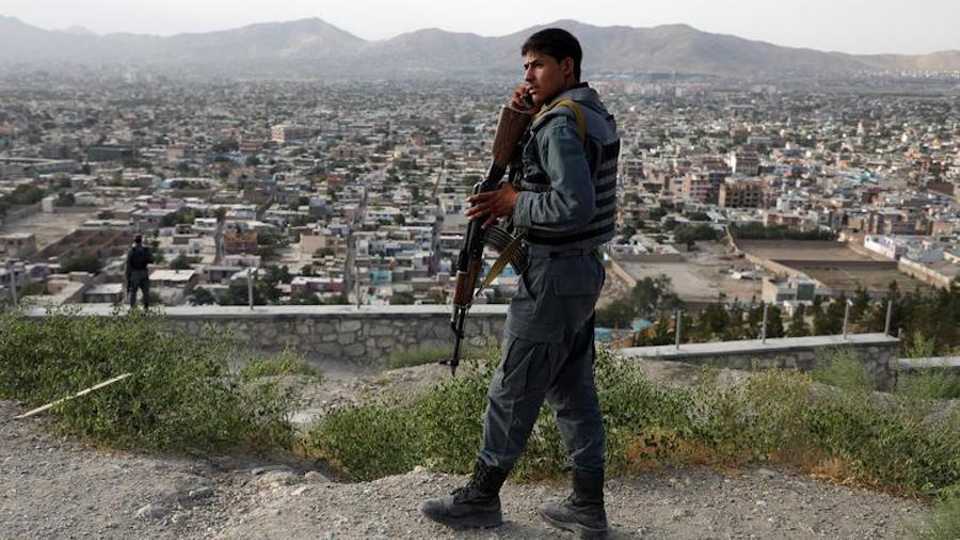 An Afghan policeman keeps watch at a hilltop in Kabul, Afghanistan July 23, 2019.