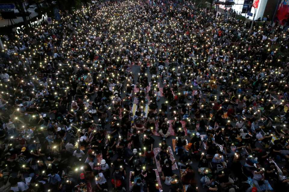 Pro-democracy protesters flash lights during an anti-government protest in Bangkok, Thailand October 25, 2020.