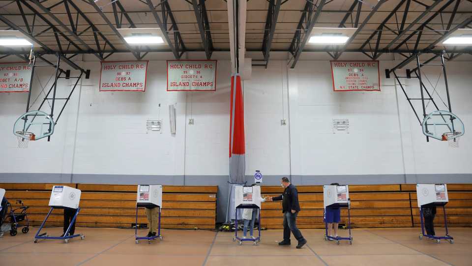 People use privacy booths to fill ballots at a polling station located in the Monsignor John D. Burke Memorial Gym at the Church of the Holy Child in Staten Island, during early voting in New York City, US, October 25, 2020.