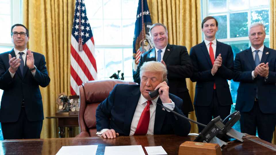 President Donald Trump talks on a phone call with the leaders of Sudan and Israel, as Treasury Secretary Steven Mnuchin (L), Secretary of State Mike Pompeo, White House Senior Advisor Jared Kushner and National Security Advisor Robert O'Brien applaud in the Oval Office of the White House. October 23, 2020.