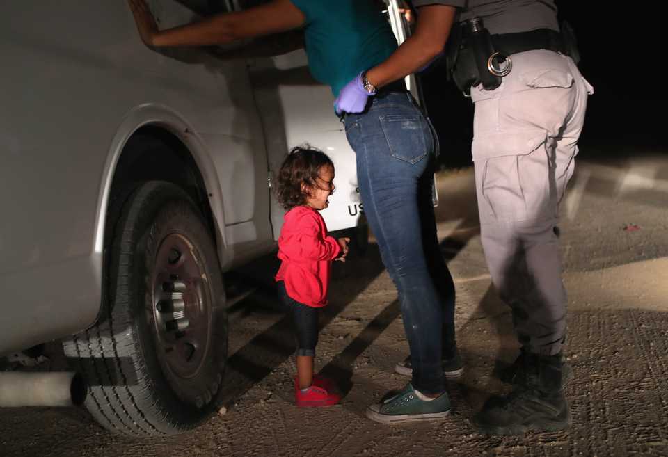 A two-year-old Honduran asylum seeker cries as her mother is searched and detained near the US-Mexico border on June 12, 2018 in McAllen, Texas.
