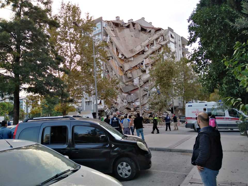 Residents look at a damaged building after a strong earthquake collapsed some buildings in the coastal province of Izmir, Turkey, October 30, 2020.