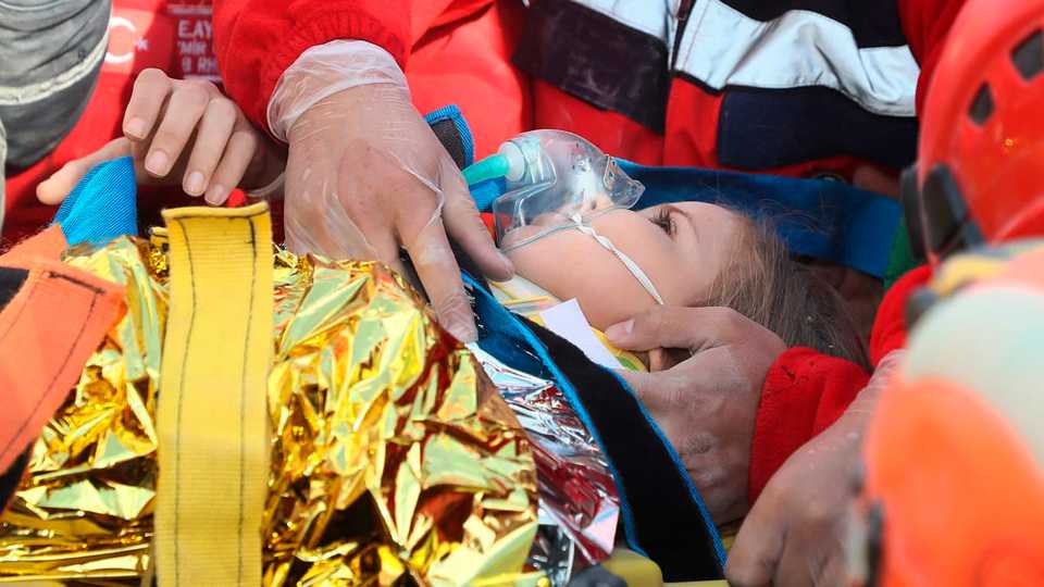 In this photo provided by the Turkish government's disaster management agency AFAD, rescue workers surround Ayda Gezgin after pulling her from the rubble of a collapsed building in Izmir, Turkey. November 3, 2020.