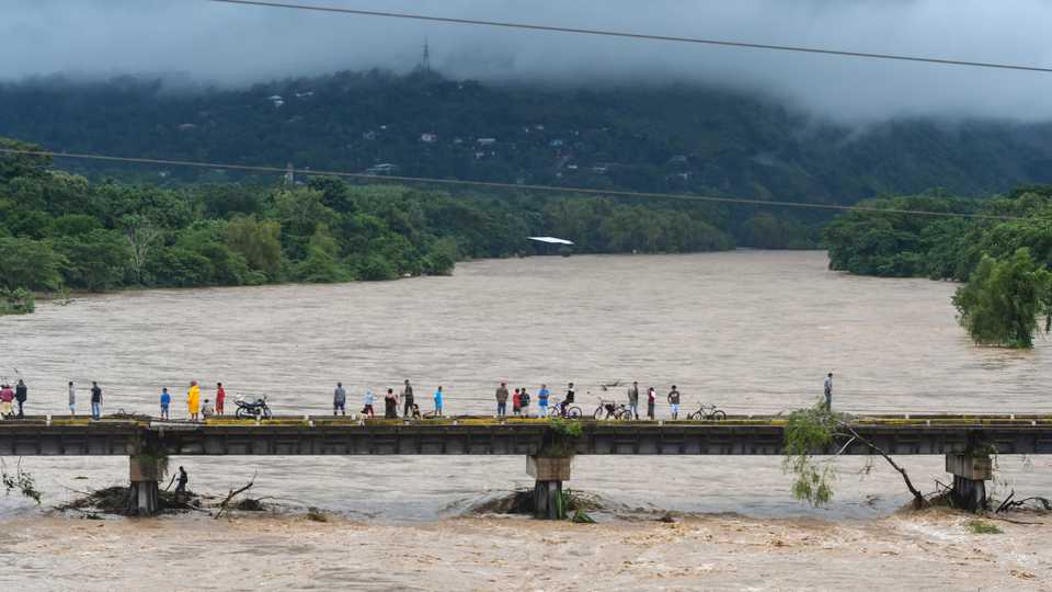 People watch the Humuya River flooding due to heavy rains caused by Hurricane Eta, in Santa Rita, northern Tegucigalpa, Honduras, on November 3, 2020.