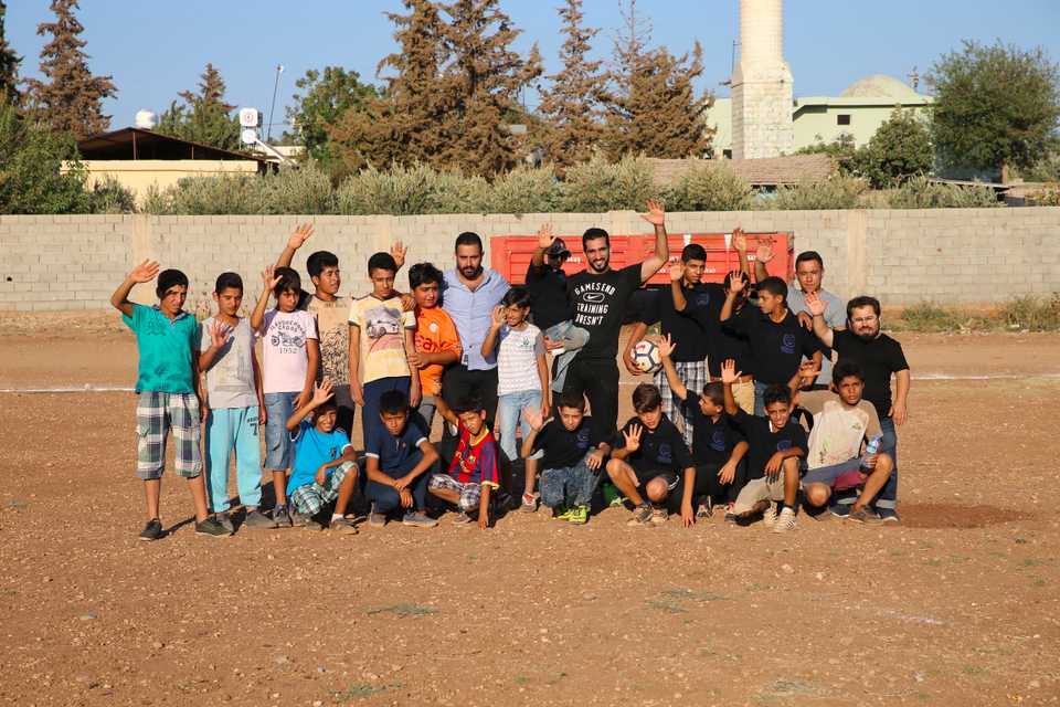 Syrian children posing for a photo with Qatars Adel Lamy. 