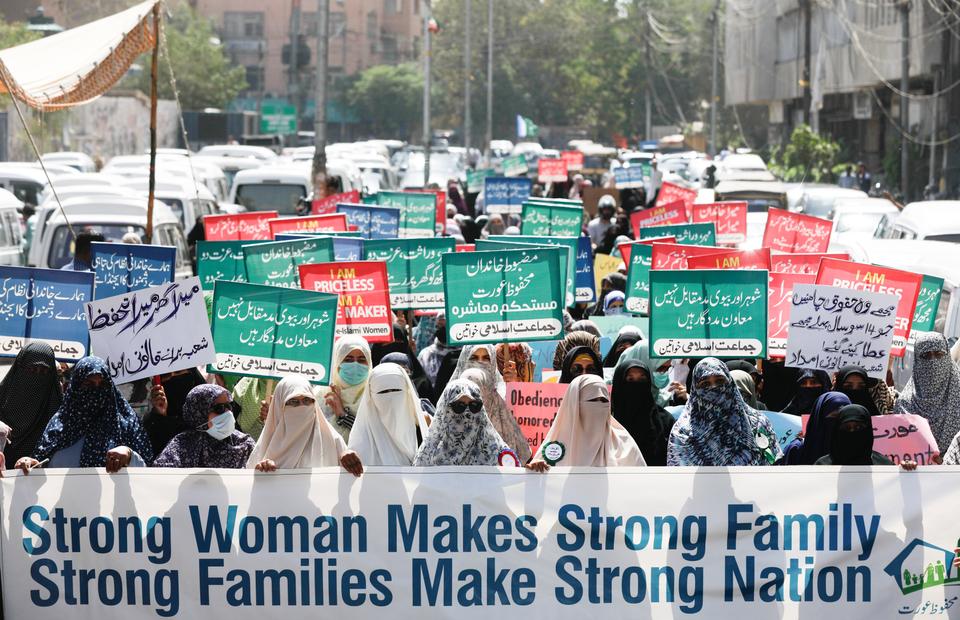 Women supporters of the religious and political party Jamaat-e-Islami hold signs as they take part in Aurat March or Women March, to mark the International Women's Day in Karachi, Pakistan March 8, 2021.