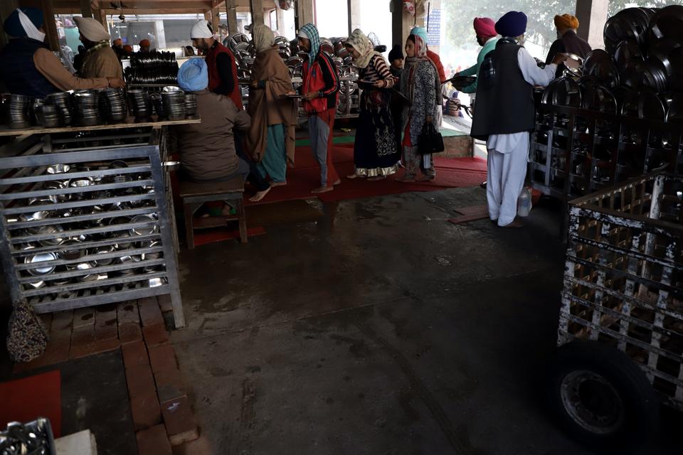 Individuals wait in a queue to enter the hall. Around 50,000-75,000 individuals eat food in the Golden Temple every day.