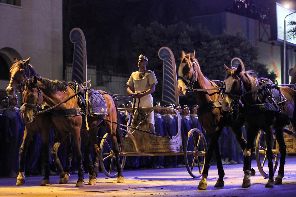 فنان يركب عربة ذات حصانين في بداية موكب 22 مومياء ملكية مصرية قديمة.