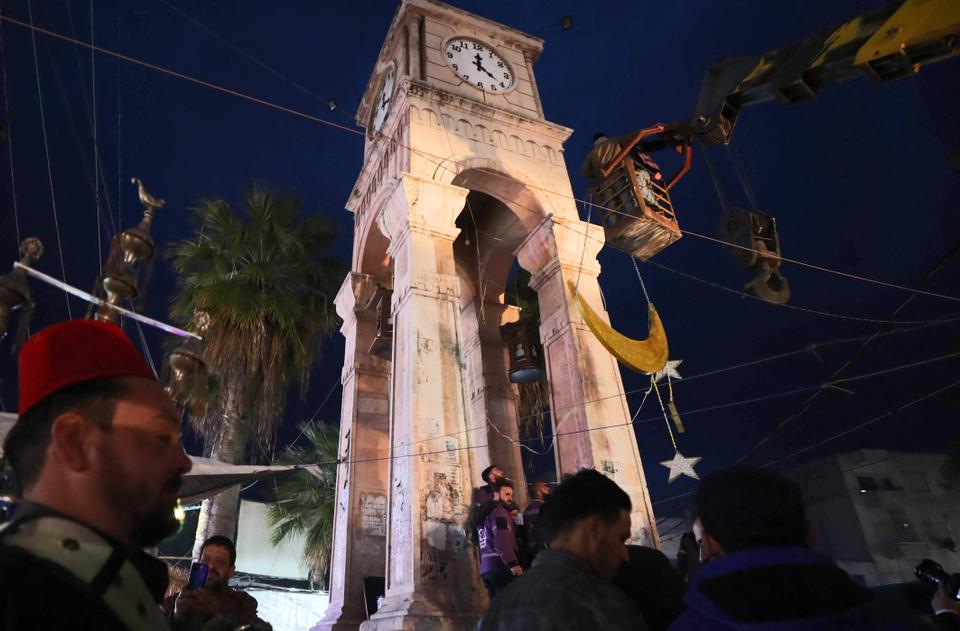 Syrians install decorations for the Muslim holy fasting month of Ramadan at the Clock Square in Syria's rebel-held northwestern city of Idlib, on April 12, 2021.