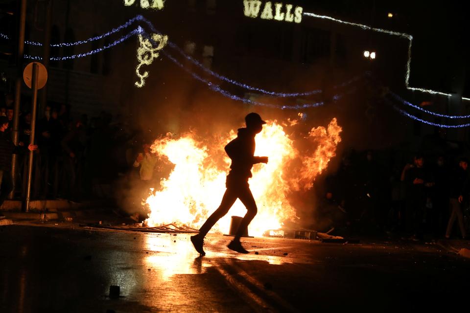 Palestinians stand around a burning barricade, during clashes, as the Muslim holy fasting month of Ramadan continues, in Jerusalem, April 22, 2021