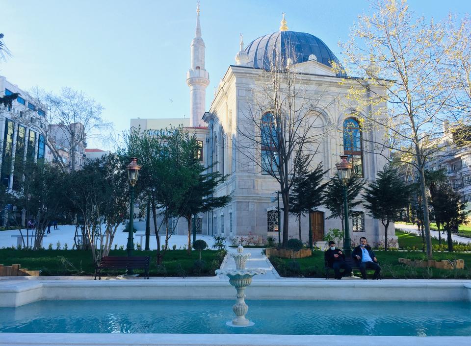 Tesvikiye mosque from the outside, with a water fountain in the foreground.