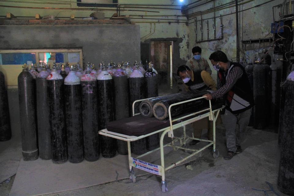 Volunteers and relatives of Covid-19 patients carry oxygen cylinders at a Srinagar Hospital in Kashmir.