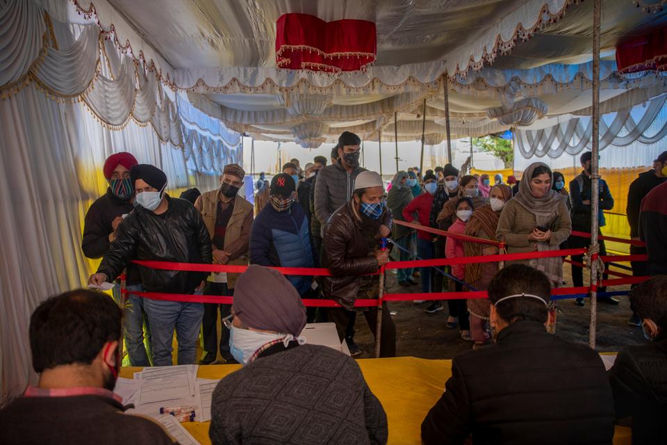 Kashmiris wait in a queue to register themselves to test for COVID-19 in Srinagar, Indian-administered Kashmir, on Wednesday, April 21, 2021.