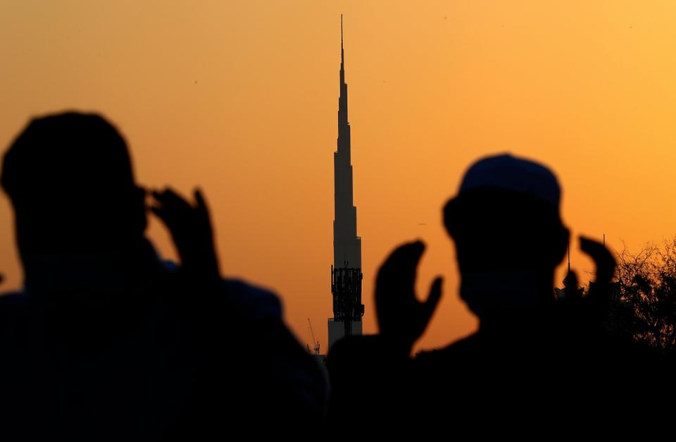 With the world's tallest building, Burj Khalifa, in background, Muslim men wearing masks to curb the spread of coronavirus outbreak perform an Eid al Fitr prayer marking the end of the holy fasting month of Ramadan in Dubai, United Arab Emirates.