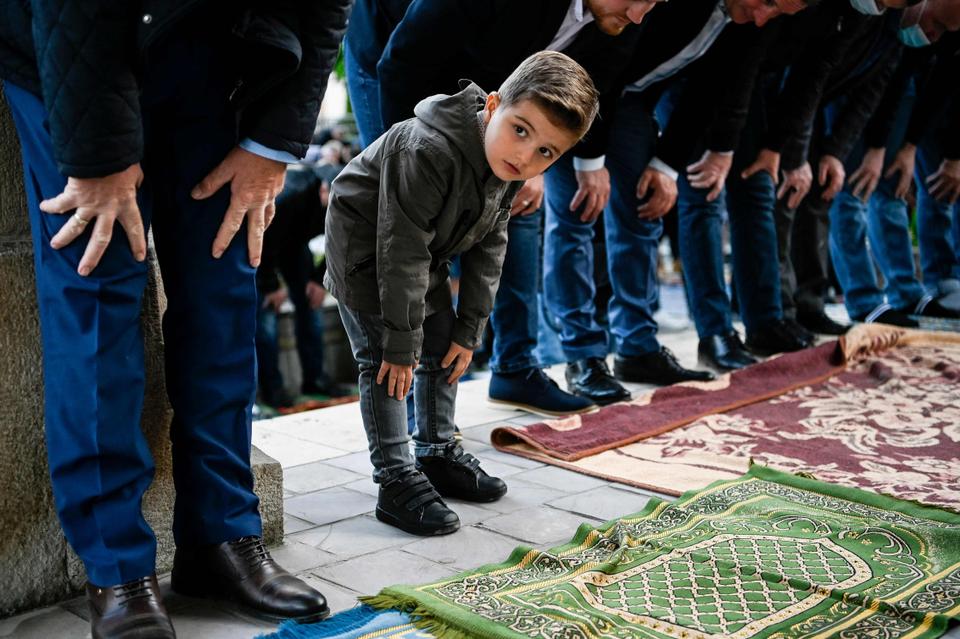 A young boy looks on as he takes part in Eid al Fitr prayer which marks the end of the holy month of Ramadan on May 13, 2021 at the Grand Mosque in Pristina, Kosovo.