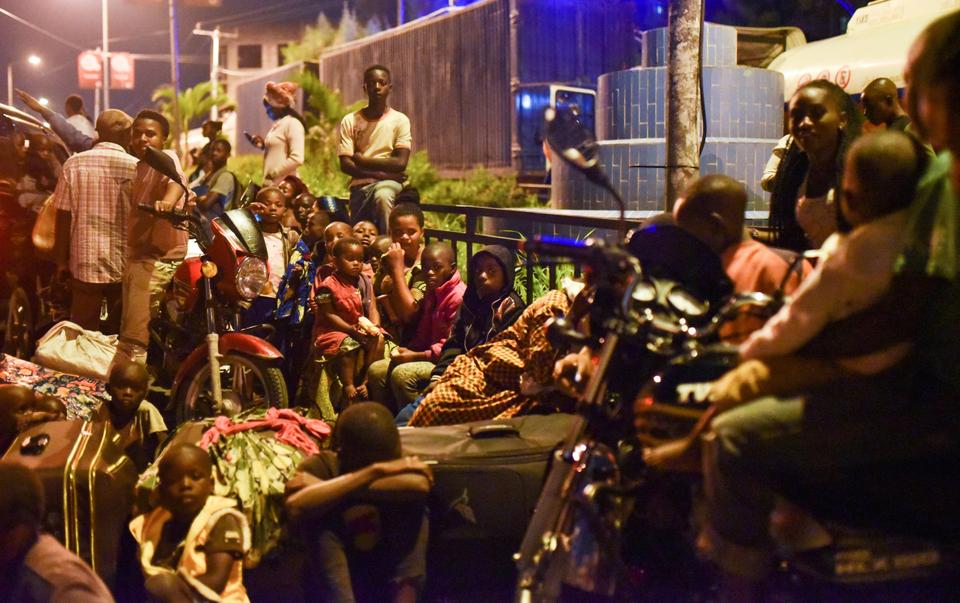 Civilians watch smoke and flames as they gather with their belongings following a volcanic activities at Mount Nyiragongo near Goma, in the Democratic Republic of Congo, May 22, 2021.