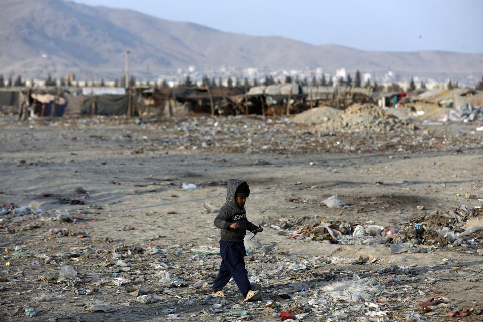 An internally displaced boy walks outside his temporary home in the city of Kabul, Afghanistan, Monday, Jan. 18, 2021.
