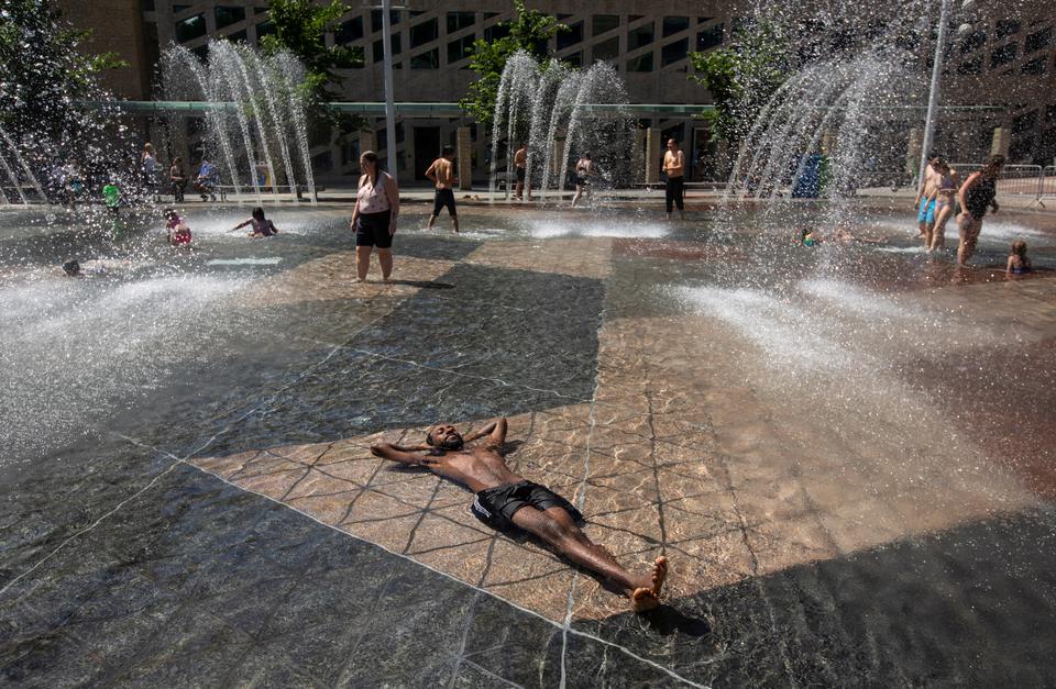 A man relaxes in the cool in the city hall pool, as temperatures hit 37 degrees Celsius in Edmonton, Alberta on June 30, 2021.