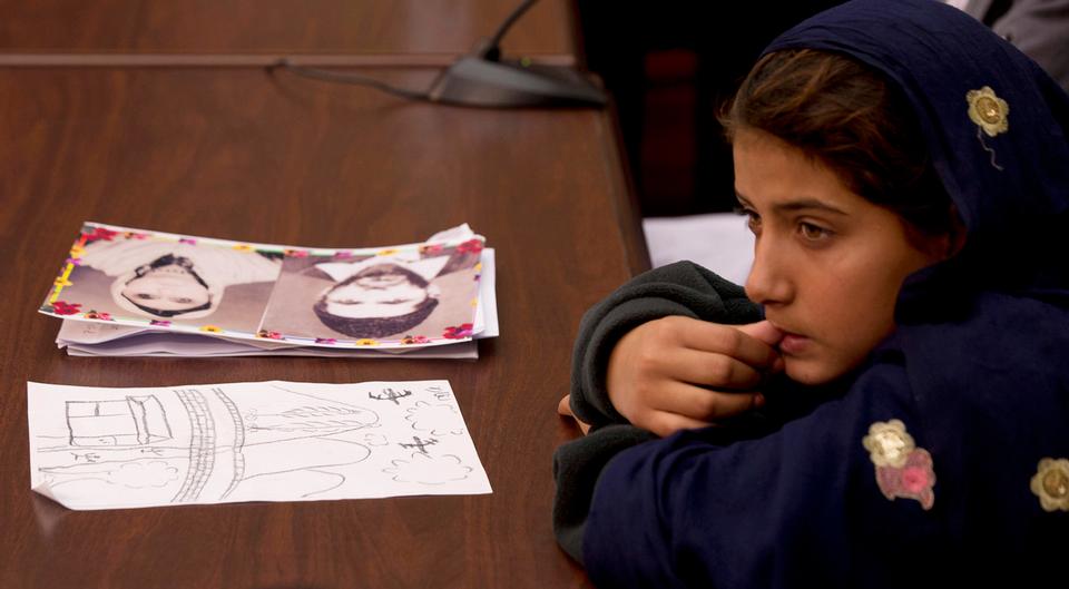 Nabila Rehman, 9, is pictured in front of a photograph of her grandmother Mammana Bibi, who was killed by a US drone strike in Pakistan, and a drawing Nabila made depicting the incident, at a news conference on Capitol Hill in Washington, October 29, 2013.