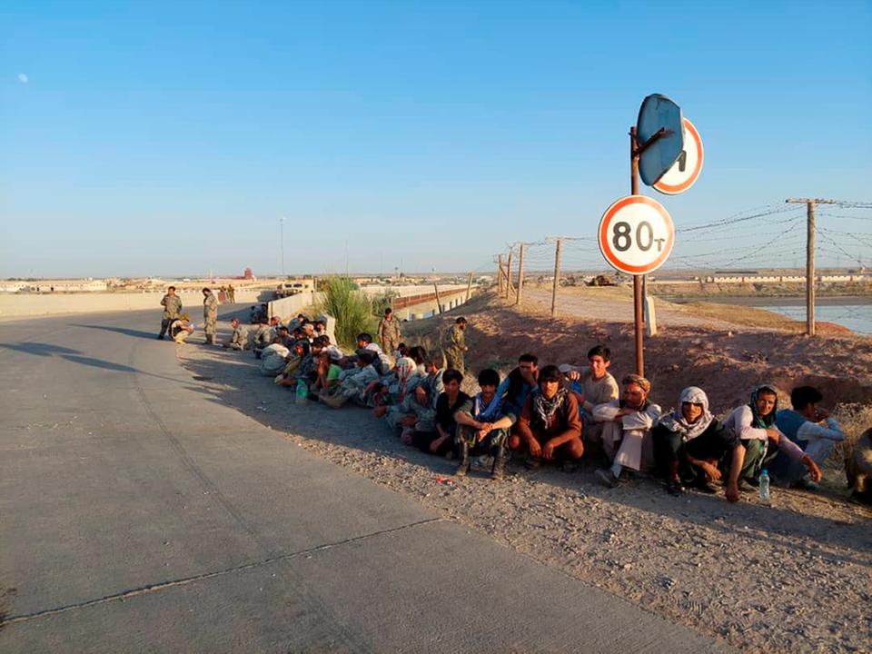 Afghan soldiers sit at a bridge next to Tajikistan-Afghanistan border in Tajikistan in this handout photo released by border security force of the Republic of Tajikistan on June 22, 2021.