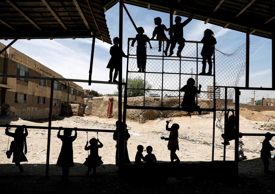 Internally displaced Afghan children play outside their shelter in Kabul on May 7, 2020.