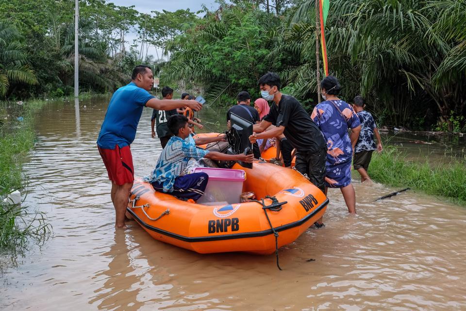 Residents trying to evacuate equipment from flooded houses due to heavy rainfall and overflowing rivers in Pekanbaru, Riau Province, Indonesia on April 22, 2021.