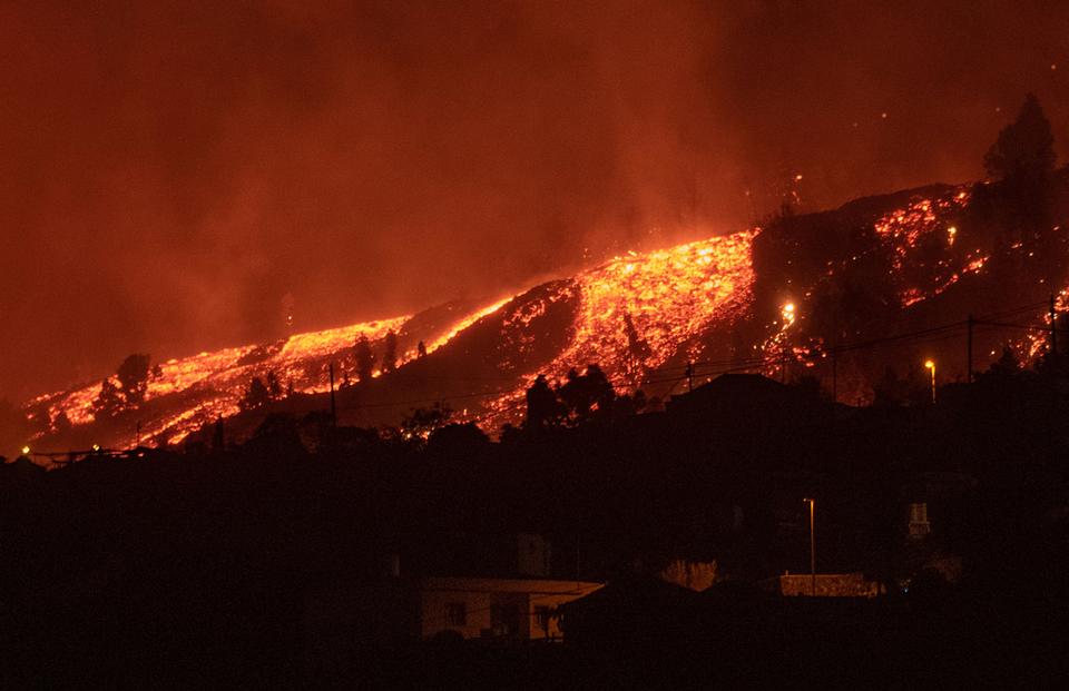 Lava flows approach houses as the Mount Cumbre Vieja erupts in El Paso on the Canary island of La Palma on September 19, 2021.