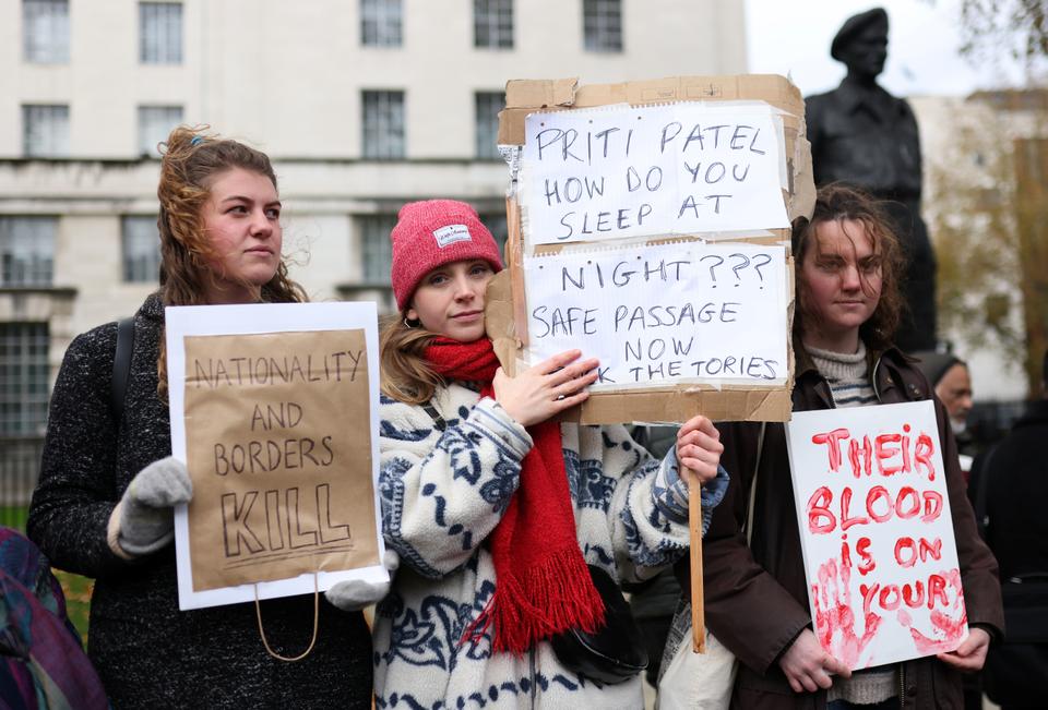 Protesters hold placards as they demonstrate against migrant deaths in London on November 27, 2021.