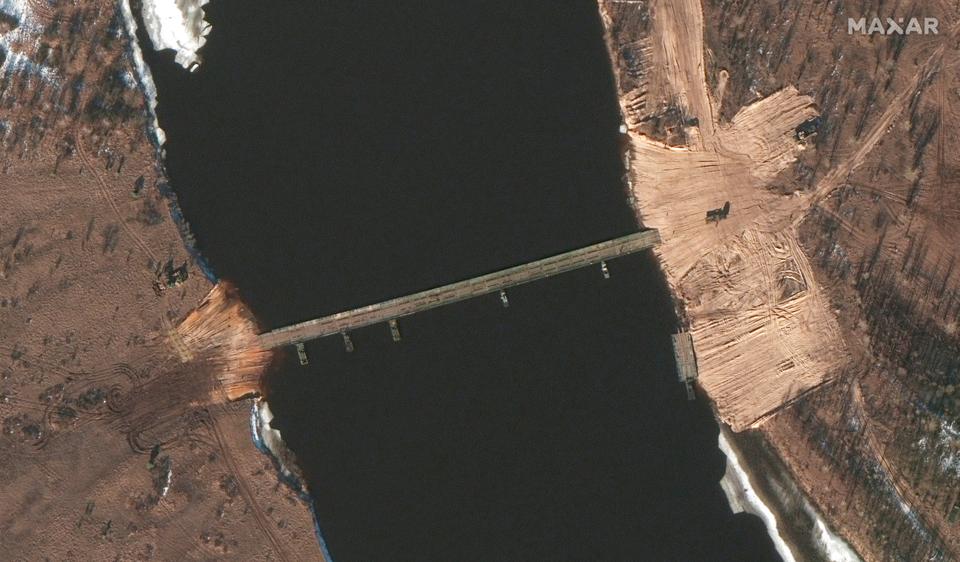 This February 15, 2022, satellite image provided by Maxar Technologies shows an overview of road construction and new pontoon bridge over the Pripyat River, Belarus.