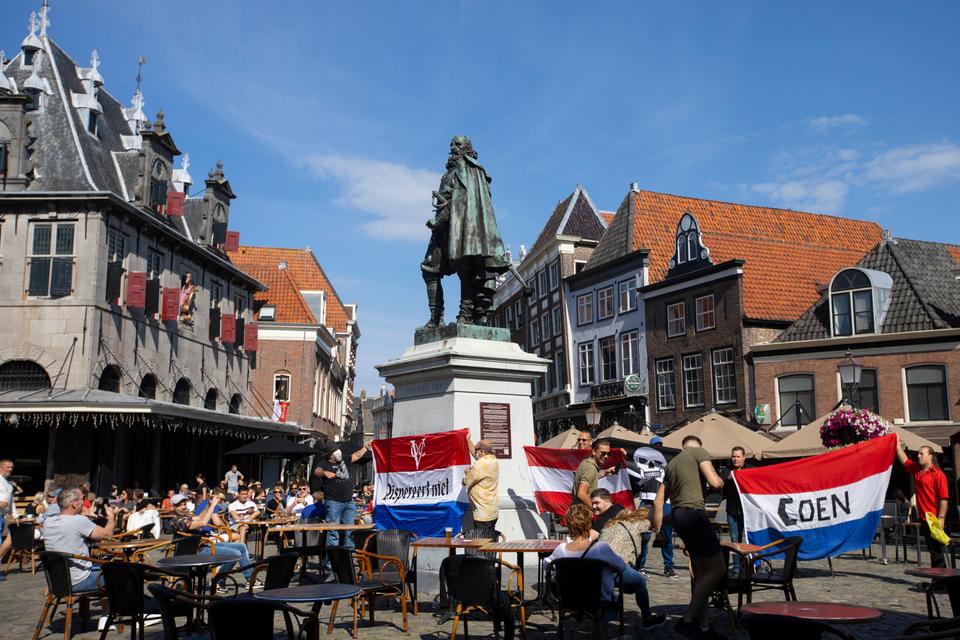 A few demonstrators hold Dutch flags at the statue of the Dutch Golden Age trader and brutal colonialist Jan Pieterszoon Coen in his hometown of Hoorn, north of Amsterdam, Netherlands in 2020.