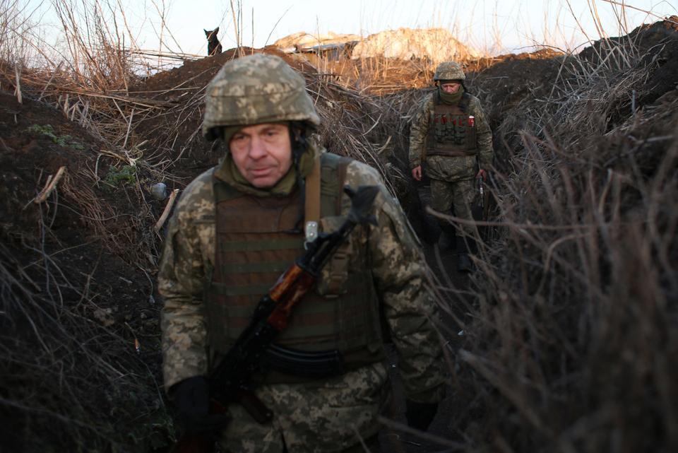 Servicemen of Ukrainian Military Forces walk along tranches on their position on the front line with Russia backed separatists, near Novognativka village, Donetsk region.