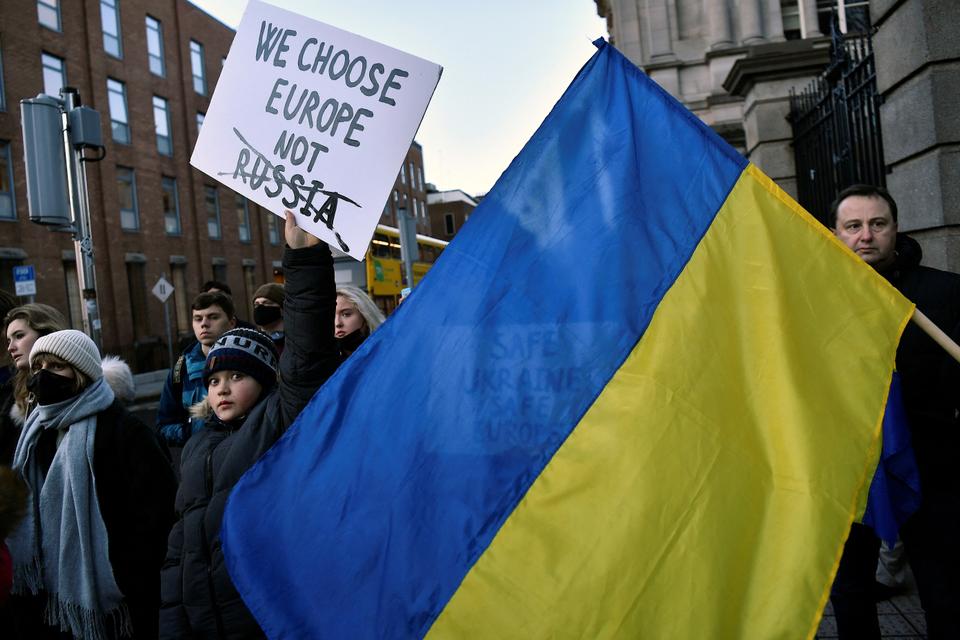 Demonstrators hold a sign and Ukrainian flag during an anti-Russia protest outside Dublin, Ireland.