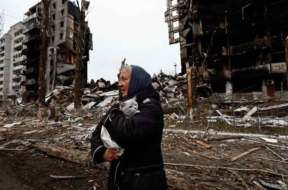Une femme porte son chat alors qu'elle passe devant des bâtiments qui ont été détruits par les bombardements russes lors de l'attaque russe contre Borodyanka, dans la région de Kiev, en Ukraine, le 5 avril 2022.
