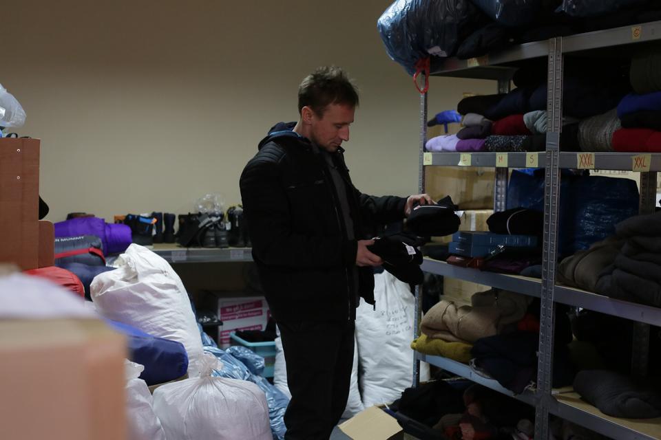 Volunteer Bartosz Frackowiak in the NGO's storage room, picking items to bring to refugees and migrants crossing the border.