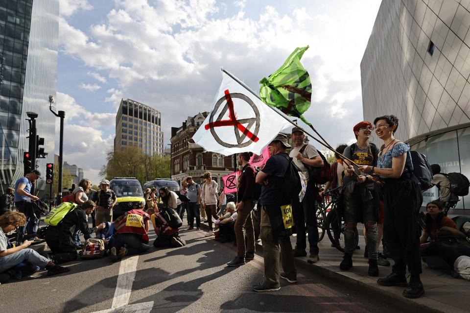 Activists from the climate change protest group Extinction Rebellion (XR) block Blackfriars Bridge in London on April 15, 2022, one of a series of actions aiming to stop the fossil fuel economy.
