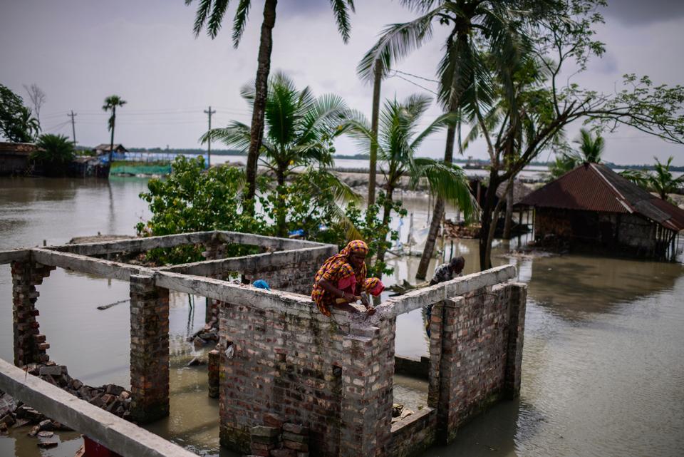 Villagers collect bricks from their house that was destroyed by natural disasters at Pratap Nagar in Satkhira, Bangladesh on Oct. 5, 2021.