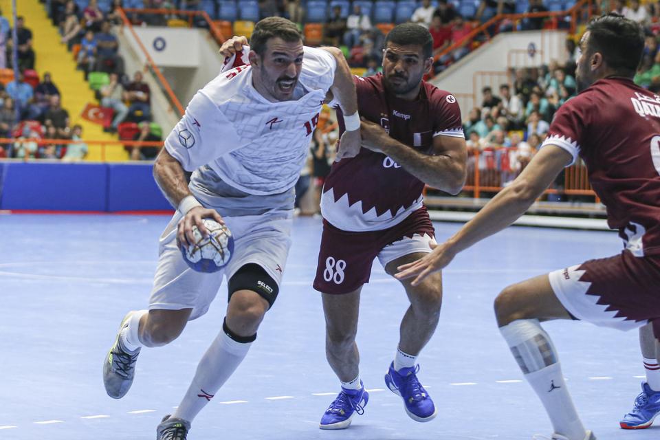 Baran Nalbantoglu (19) of Turkiye competes with Moustafa Heiba (88) of Qatar during men's handball match between Turkiye and Qatar. — Anadolu Agency