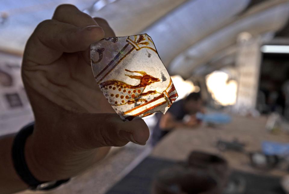 Archaeologist Elena Kogan Zahavi of Israel's Antiquities Authority displays an artifact recovered from a mansion dating back to the early Islamic period between the eighth and ninth centuries, in the Bedouin town of Rahat in Israel's southern Negev desert on August 23, 2022.
