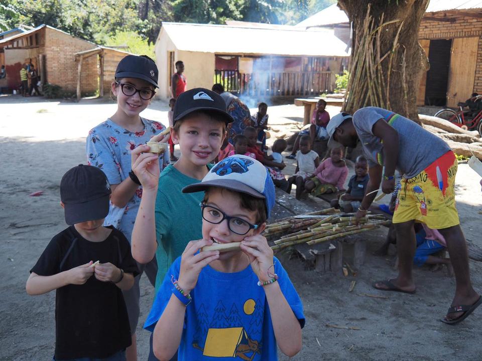 « Voyager avec 4 enfants, c'est comme voyager avec un mini ouragan », écrit Lemay sur les réseaux sociaux.  De gauche à droite : Laurent, Mia, Leo et Colin, profitant de la canne à sucre dans le petit village de Matema au sud de la Tanzanie.