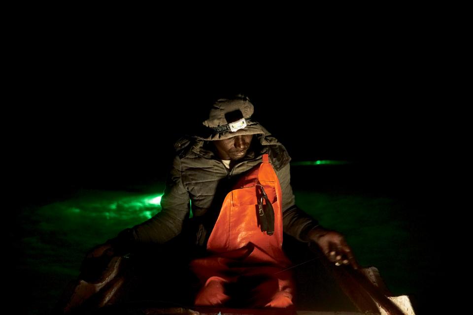 Bouba, the captain, steers the boat off the coast of Dakar, Senegal, to the Madeleine islands.