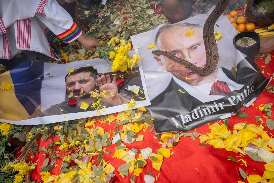 Shamans display posters of Ukrainian President Zelensky (L) and Russian President Putin while executing a ritual.