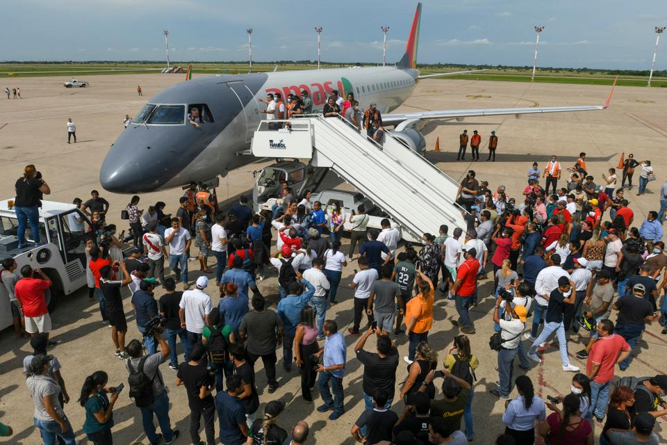 Supporters of Santa Cruz region opposition leader Luis Fernando Camacho stand on the runway to avoid departures of flights at the Viru Viru airport in Santa Cruz, Bolivia.