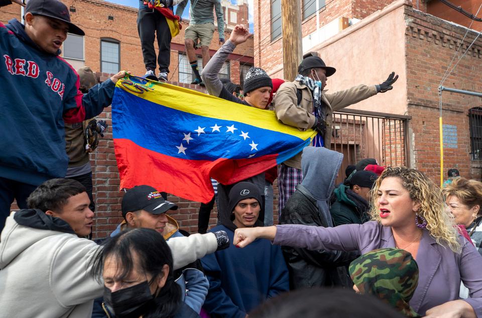 A migrant, far left, reaches to bump fists with a local resident demonstrating in support of migrants in downtown El Paso, Texas.