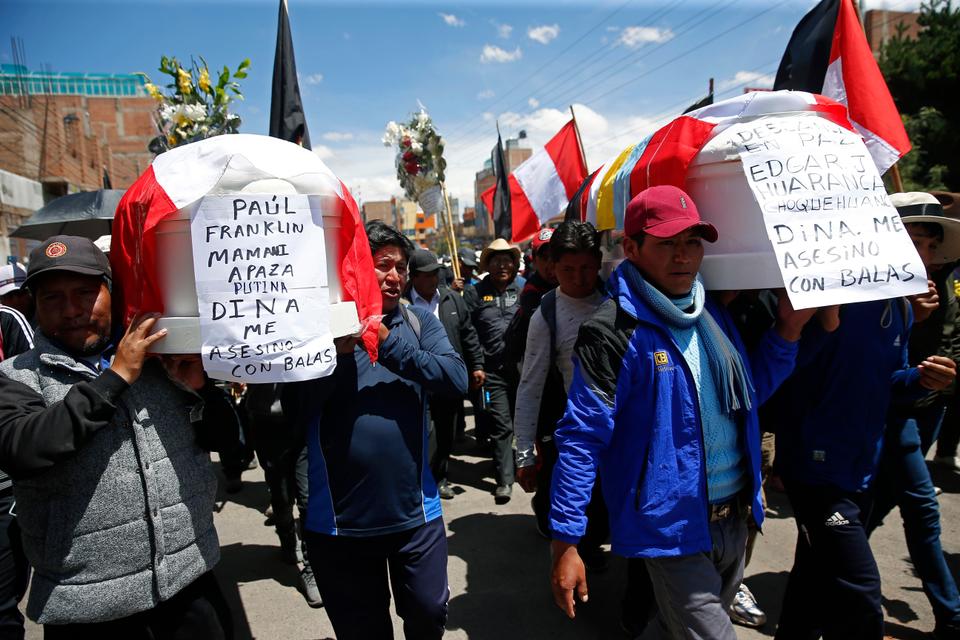 Residents carry coffins with the names of the dead and the message: 