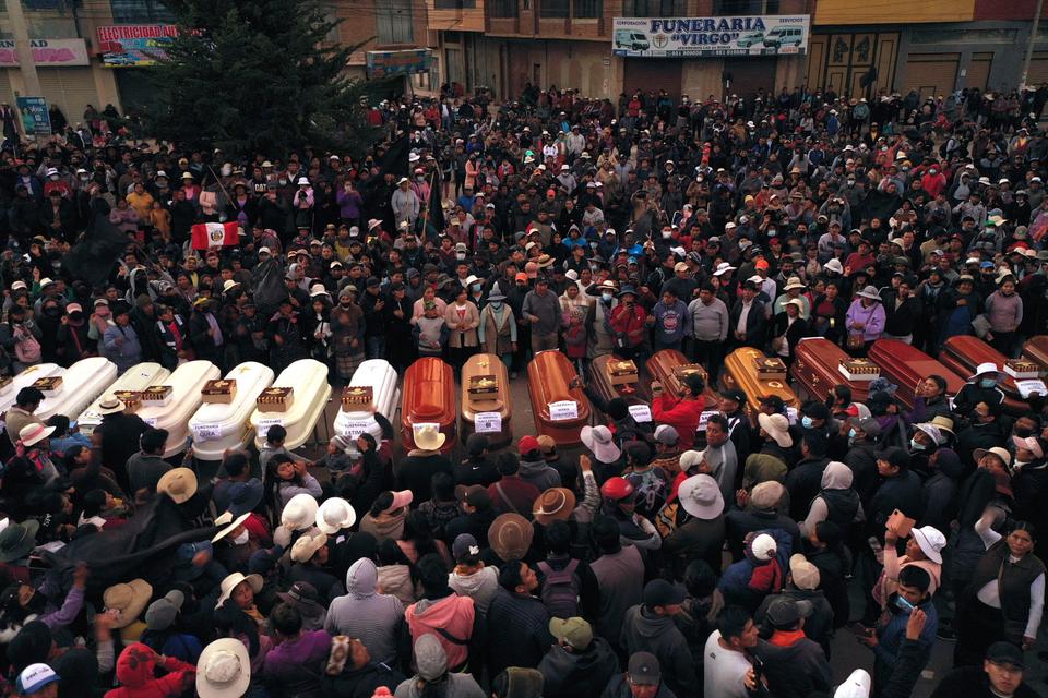 Residents surround coffins during a vigil for the more than dozen people who died during the unrest in Juliaca.