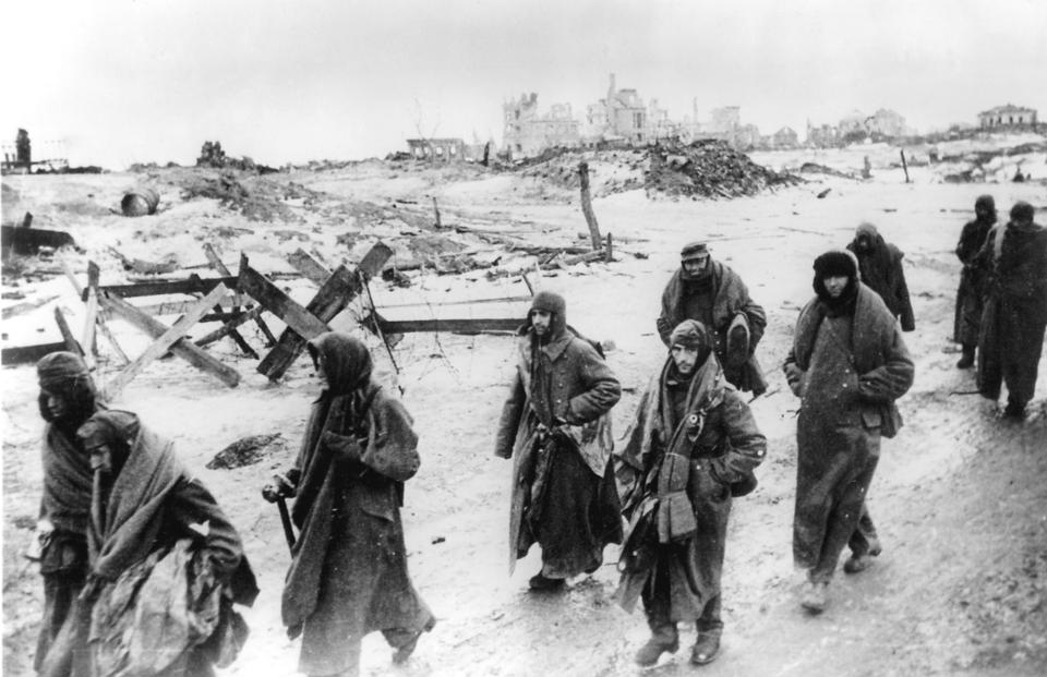 In this early 1943 photo, captured German soldiers, their uniforms tattered from the battle, make their way in the bitter cold through the ruins of Stalingrad, Russia.